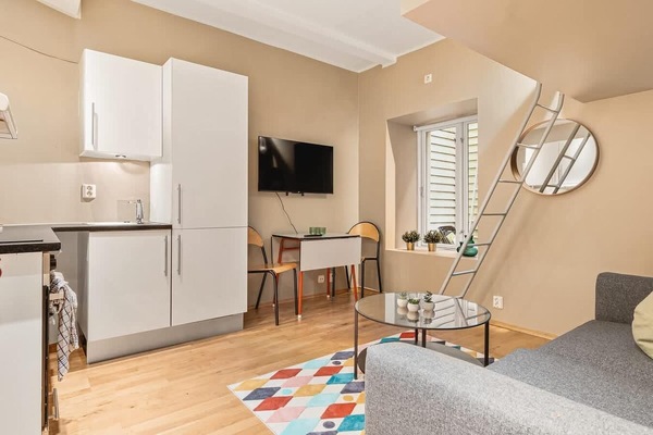 Stylish and functional with hardwood floors, cozy seating, dining space, and a bright white kitchen.