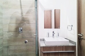 Bathroom features a glass shower enclosure, a sink with granite countertop, and a mirror above.