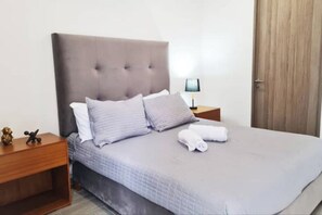 Relax in a cozy retreat with a large bed, tufted headboard, and comfortable pillows.