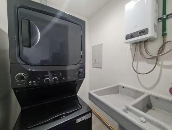 Compact kitchen area with microwave oven, sink, and countertop space.