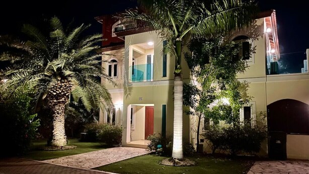 Un bâtiment à deux étages doté d’une entrée bien éclairée, d’une porte bien visible et d’un balcon.