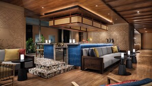 Uma área de estar moderna com teto de madeira, um bar e vários assentos, incluindo sofás e mesas.