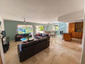 Relax in this stylish living area with a large sofa, armchair, and dining table.