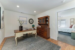 Une chambre à coucher comprenant un lit, une commode, un bureau et une fenêtre avec des stores.