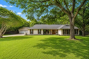 A single-story house with a front porch, a garage, and a well-maintained lawn.