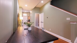 A dining area with a long wooden table, chairs, and a potted plant. - Spacious 4-bedroom townhome in St. Louis  (St. Louis)