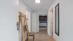 Ein Flur mit einer Holzleiter, einem Stuhl und einem gerahmten Bild an der Wand.
