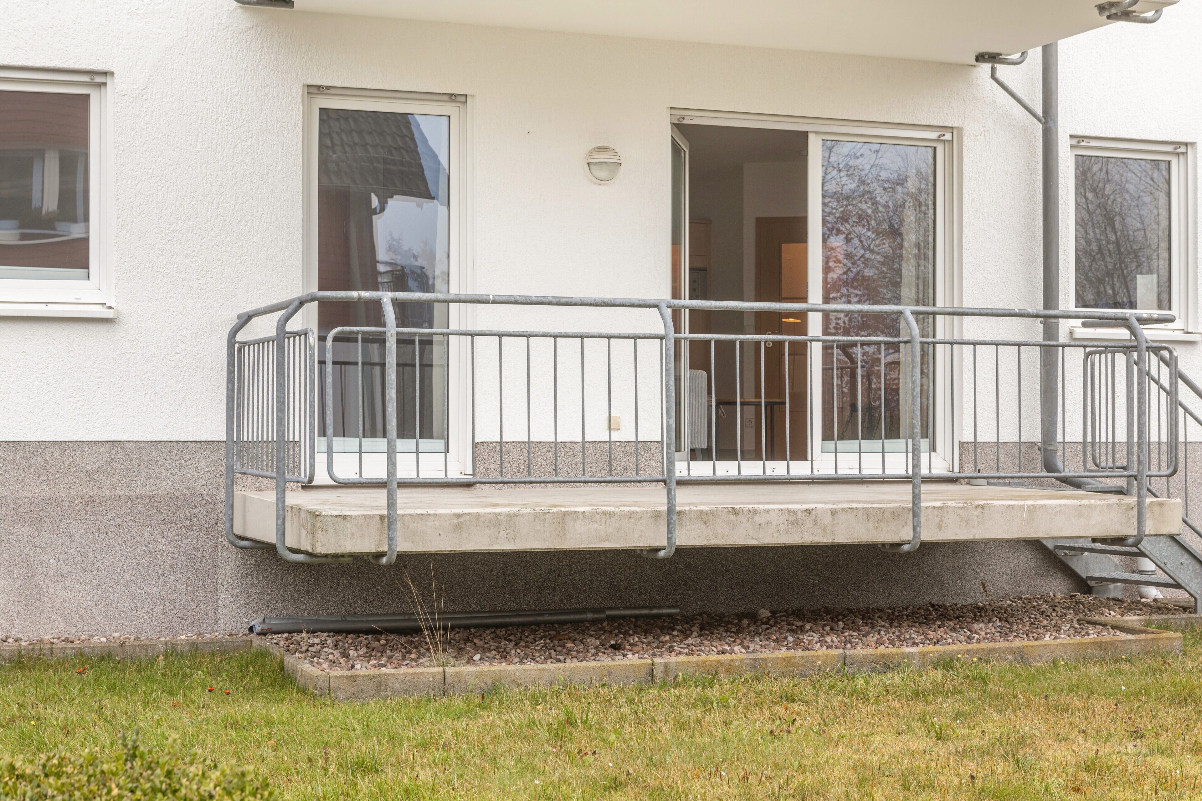 Un bâtiment doté d’un balcon, d’une porte et d’une fenêtre.