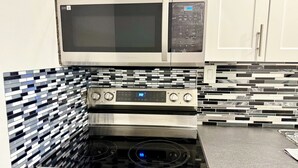 Una cocina con microondas, horno y estufa de acero inoxidable.