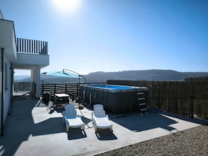 A pool area with lounge chairs, a hot tub, and a view of the mountains. - House Mirador al atlántico, Razo (Carballo)
