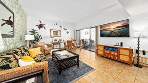 Ein Wohnzimmer mit einer Couch, einem Couchtisch und einem Essbereich mit Stühlen und einem Tisch.