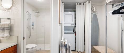 Un baño moderno con ducha, inodoro y un tendedero.