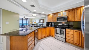 Une cuisine moderne avec des meubles en bois, des appareils en acier inoxydable et un grand îlot central.