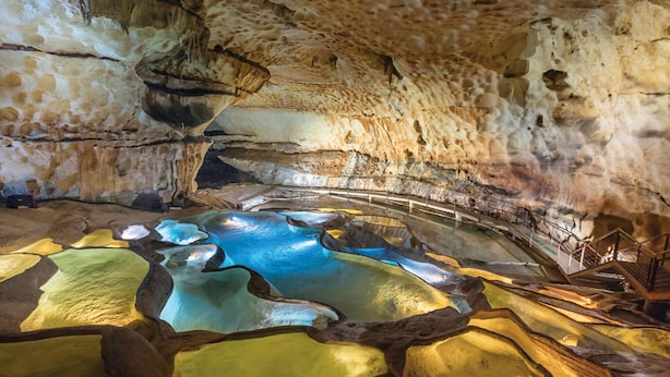 Eine Höhle mit natürlichen Felsformationen und einem Wasserbecken.