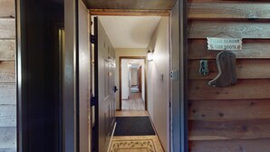 A wooden interior hallway with a sign on the wall instructing to remove luggage. - Ski-in Ski-out  | Large Windows | High Ceilings | Gold Creek 307 (Angel Fire)