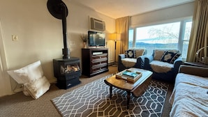 Ein gemütliches Wohnzimmer mit Kamin, einer Couch, einem Couchtisch und einem Fernseher.