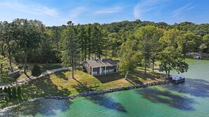 A house surrounded by trees and a lake.