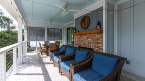 A covered porch with wicker furniture, ceiling fans, and string lights. - OFF THE GRID-Custom Showplace w/ Private Pool;Multiple Decks;3 Minute Walk to Beach (Edisto Beach)