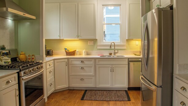 A kitchen with white cabinets, a stainless steel range hood, a refrigerator, and a window above the sink. - Historical Victorian with Modern Touch. Garage with EV Charger (Sonora)