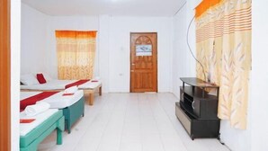 A room with two beds, a television, and a door. - RedDoorz @ St Anthony Beach Resort (Asturias)