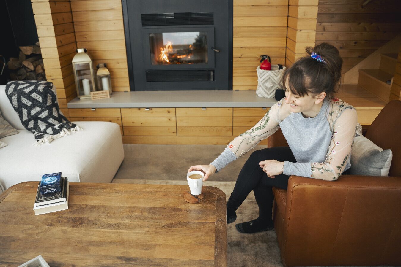 Una sala de estar acogedora con chimenea, una mesa de centro y un sofá.