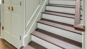 A staircase with white steps and a wooden handrail, leading to a door with brass handles. - The Manor 93 A&B - 2 Newly Renovated Units in Downtown Charleston! (Charleston)