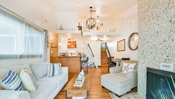 A modern living room with a sofa, armchairs, a coffee table, and a fireplace.