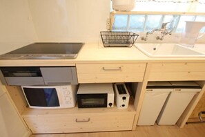 Uma cozinha compacta com micro-ondas, torradeira e lava-louças.
