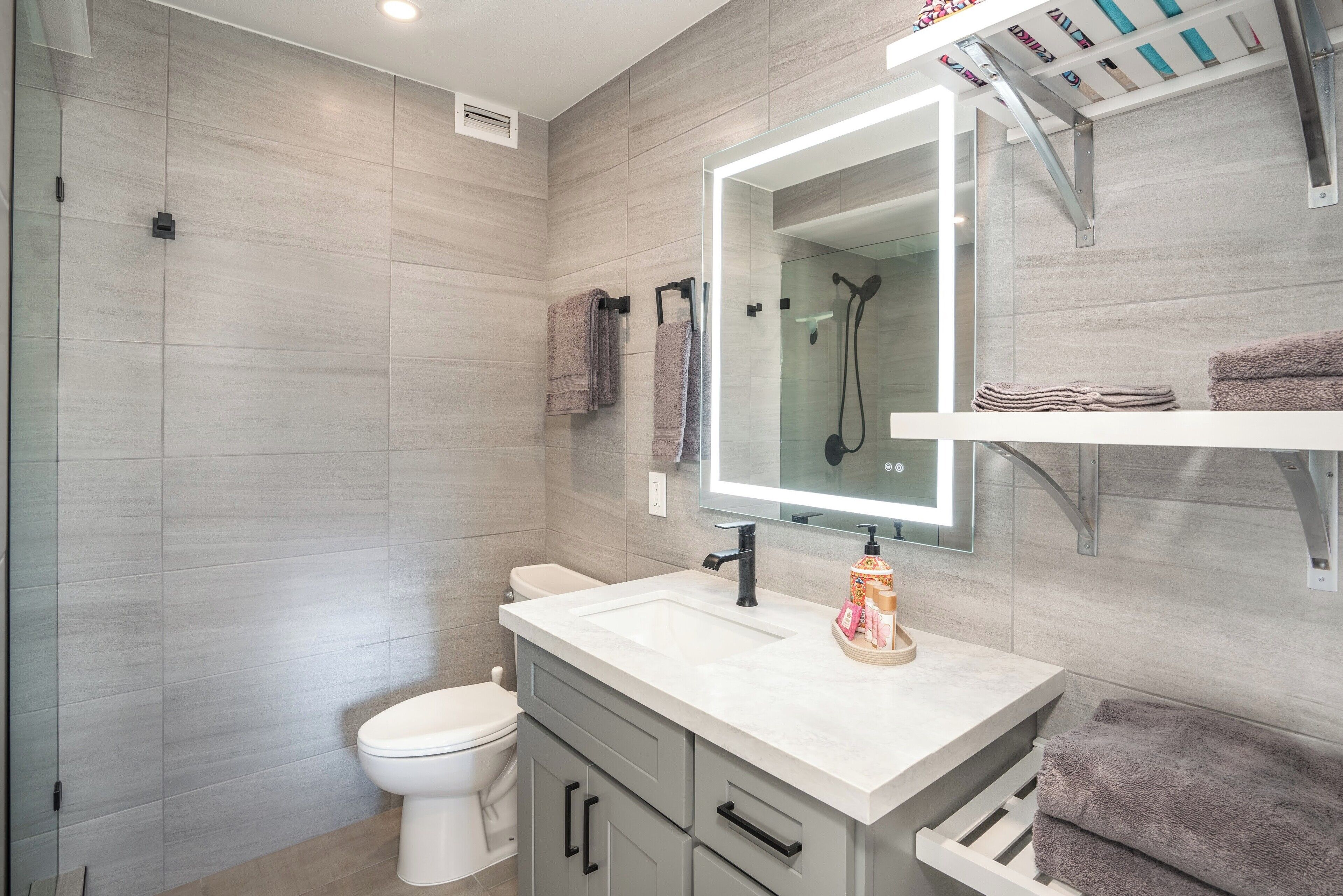 A modern bathroom with a toilet, sink, and shower.