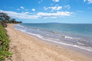 On the beach, white sand, sun loungers, beach umbrellas