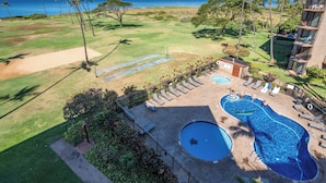 A hotel with a swimming pool, lounge chairs, and a view of the ocean. - Hip Hawaiian Seaside Vistas (Kihei)