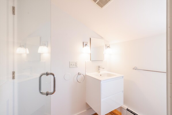 A modern bathroom with a white sink, mirror, and towel rack. - Relax on Nantucket in our Cozy, 1-bedroom condo with AMAZING views! (Nantucket)