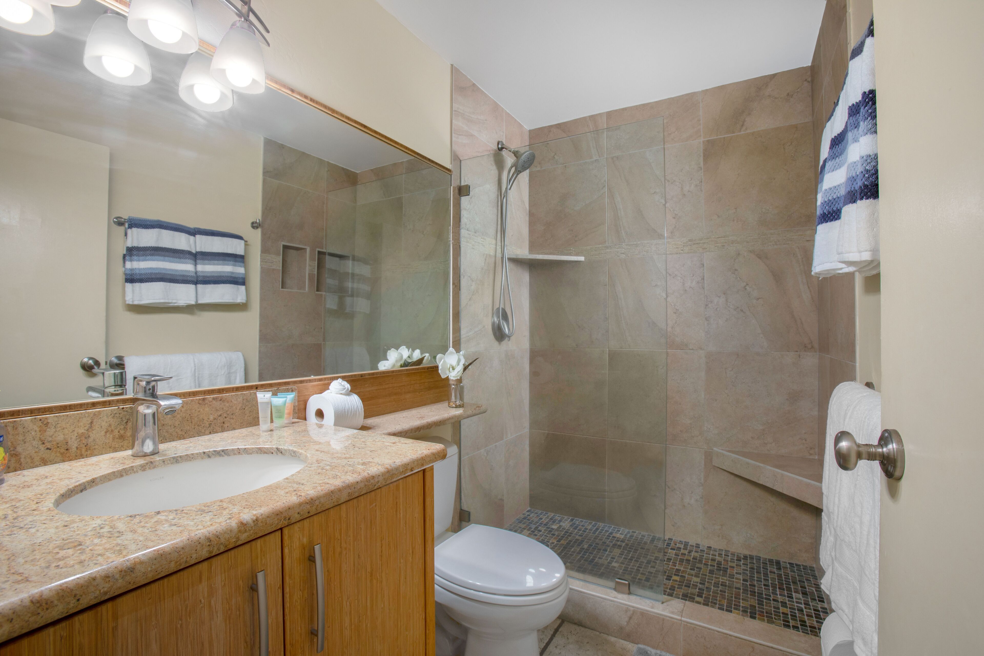 A bathroom with a sink, toilet, and shower.