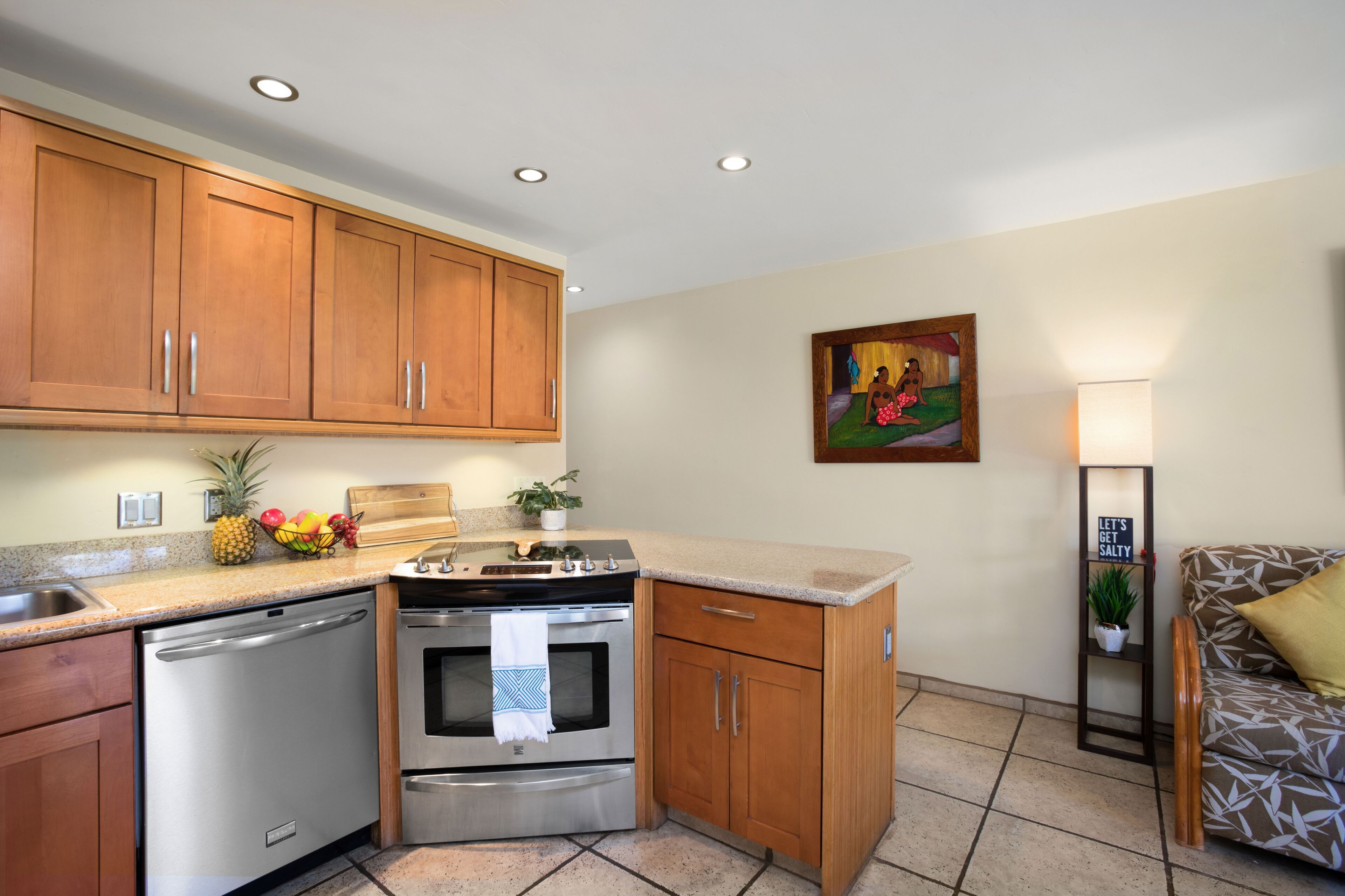 A compact kitchen with wooden cabinets, stainless steel appliances, and a tiled backsplash.