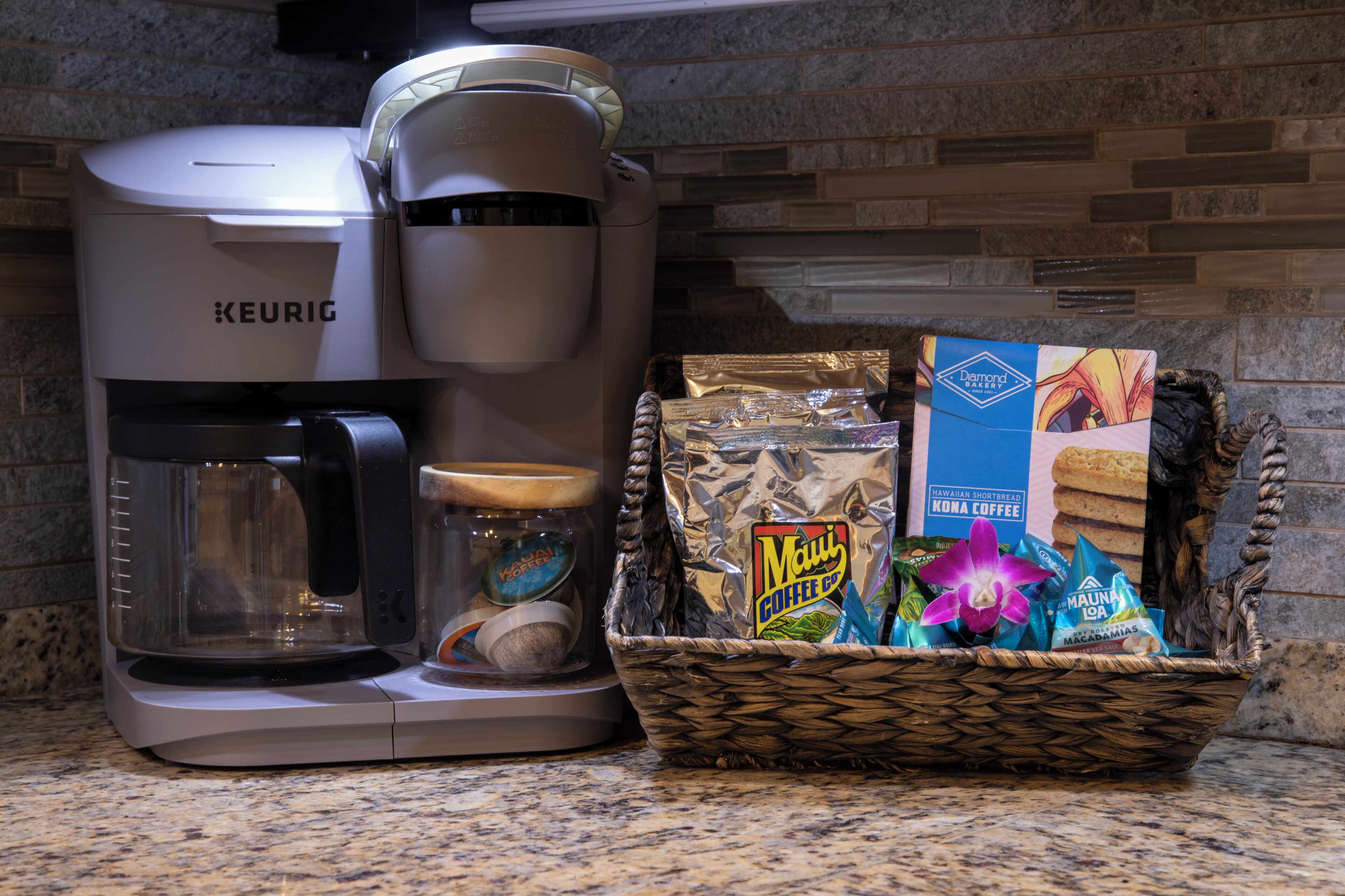 A Keurig coffee maker, a basket of coffee bags, and a jar with a lid on a kitchen counter.