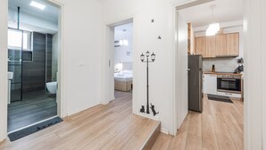 Eine moderne Küche mit Holzausbau, einem Edelstahlkühlschrank und einem eingebauten Backofen.