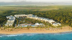 A resort with multiple buildings, a beach, and a view of the ocean.
