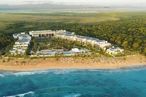 Un resort con varias construcciones, una playa y vista al océano.