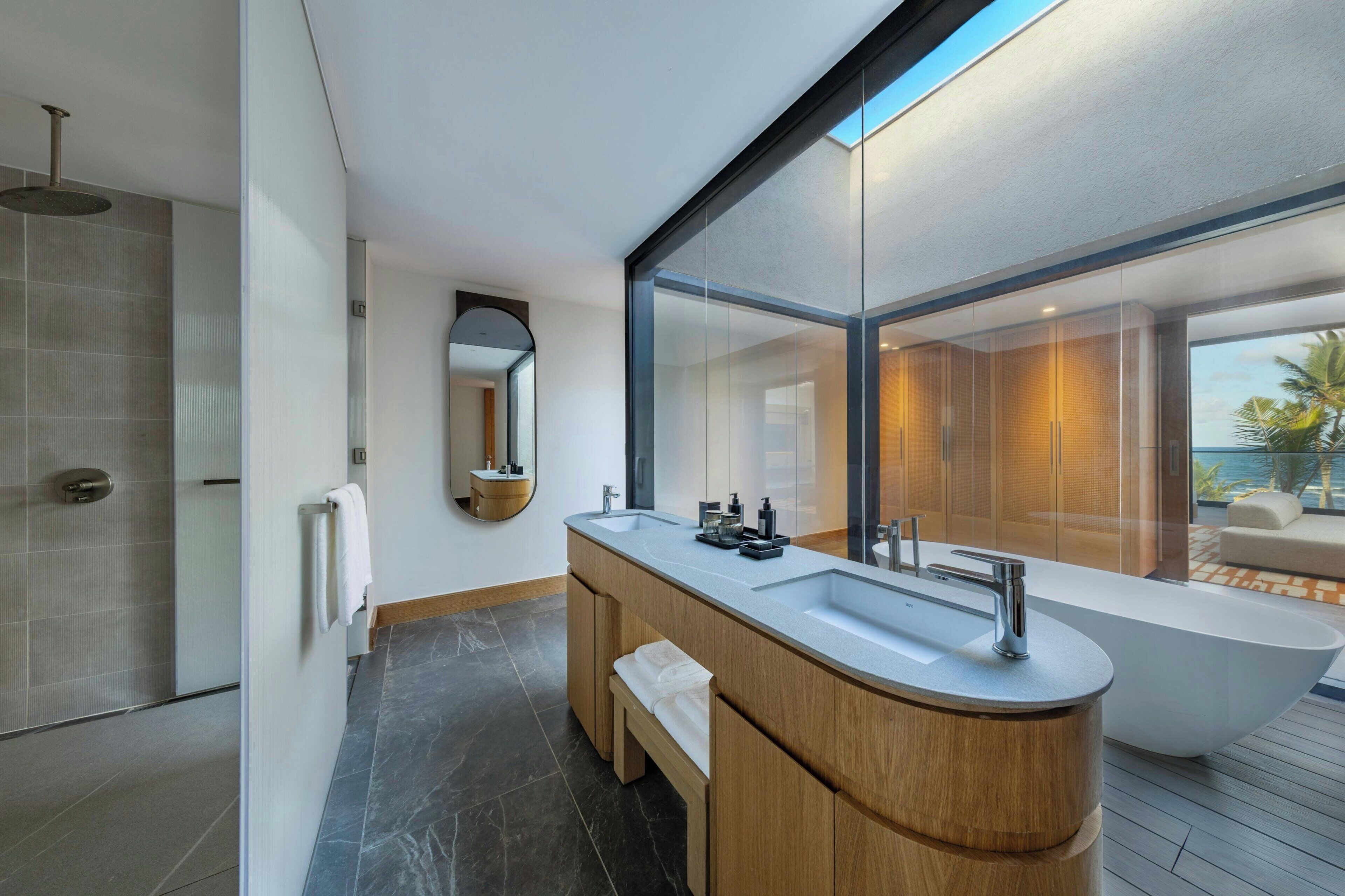 A modern bathroom with a large sink, a bathtub, and a shower area.