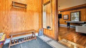 Un interior de madera con un banco, una mesa y un felpudo.