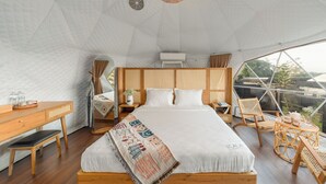A spacious, well-lit tent-style room with a large bed, wooden furniture, and a view of the outdoors. - Olala Glamping (Bao Lam 1)