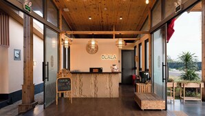 A reception area with a wooden ceiling, a marble counter, and a view of the outdoors. - Olala Glamping (Bao Lam 1)
