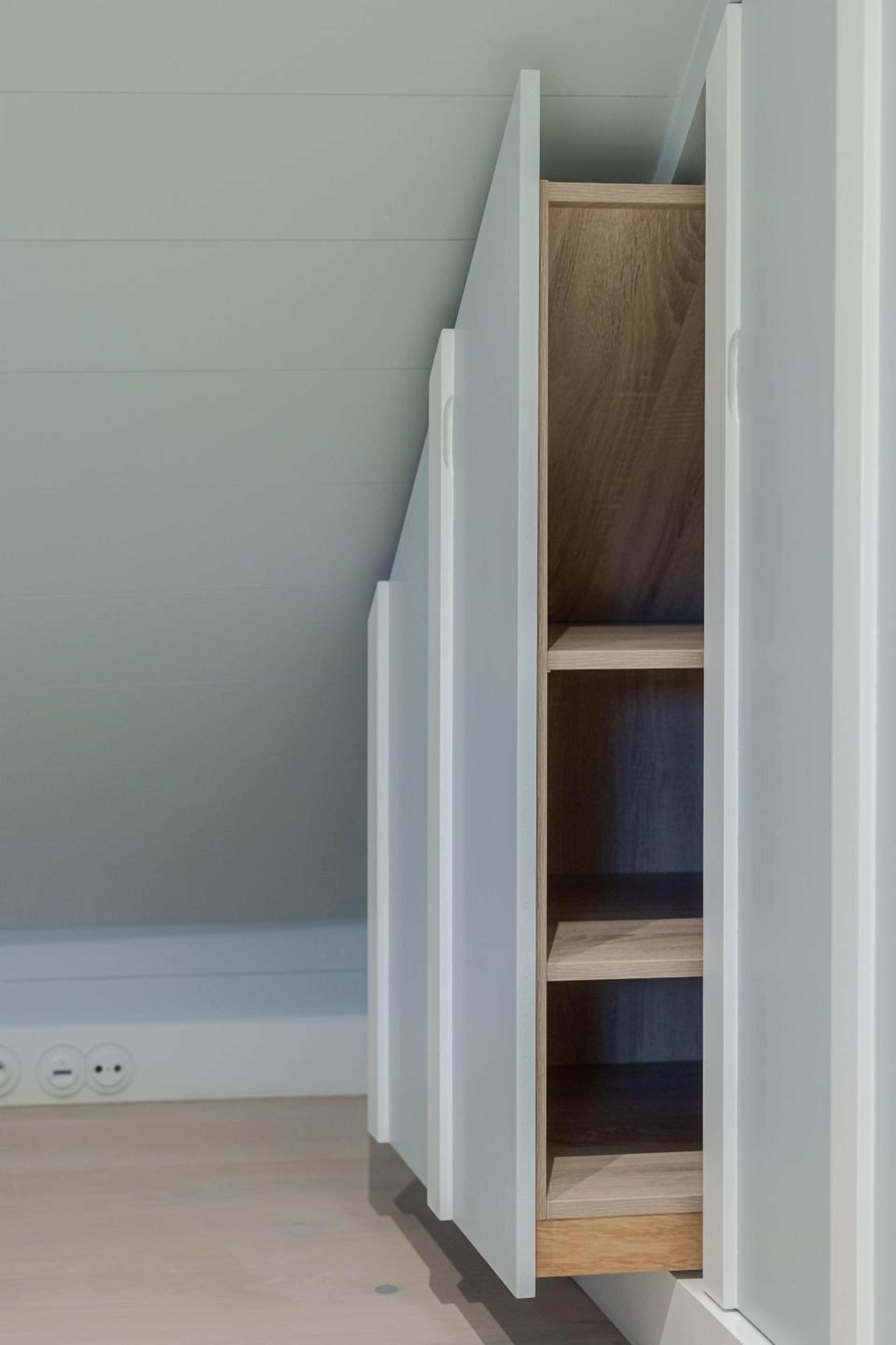 Una habitación con un armario blanco y una estantería de madera.