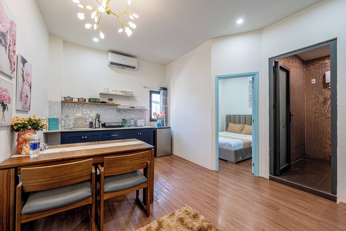 A compact living space with a kitchenette, a dining area, and a bedroom.