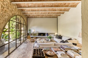 Un salón amplio con chimenea, ventanas grandes y una pared de piedra.