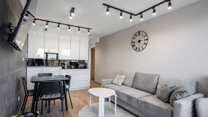 A modern living space with a kitchen, dining area, and seating area. - Mistral Porta Mare by Interhome (Dziwnówek)