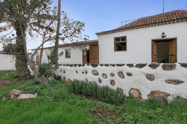 Un edificio tradicional con pared de piedra, puertas de madera y techo de tejas.
