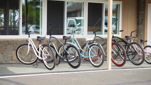 Una fila di biciclette parcheggiate di fronte a un edificio con ampie vetrate.