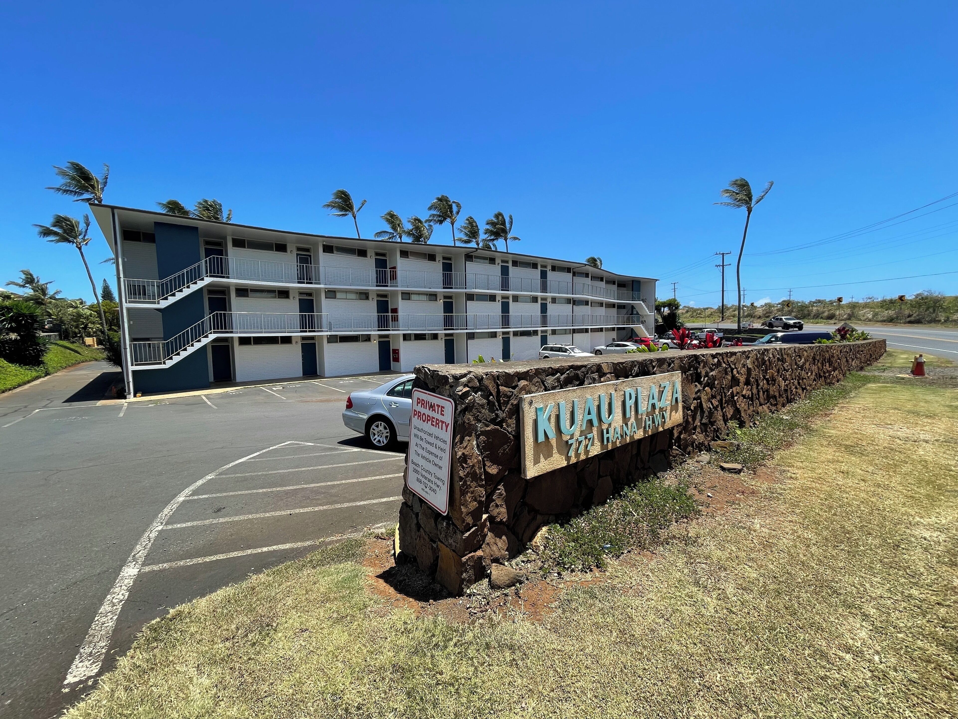 A multi-story building with a parking lot and a sign indicating it is private property.