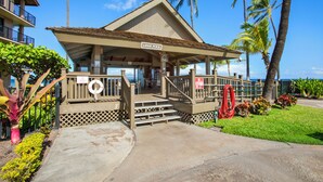 A building with a sign reading "LANAI POOL" and a lifeguard stand.